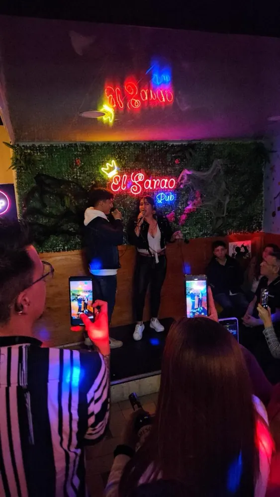 El público grabando al cantante desde las mesas